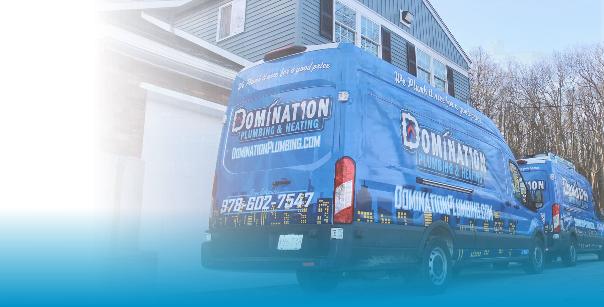 Two Domination Heating & Plumbing vans outside residential home in Leominster, Massachusetts.